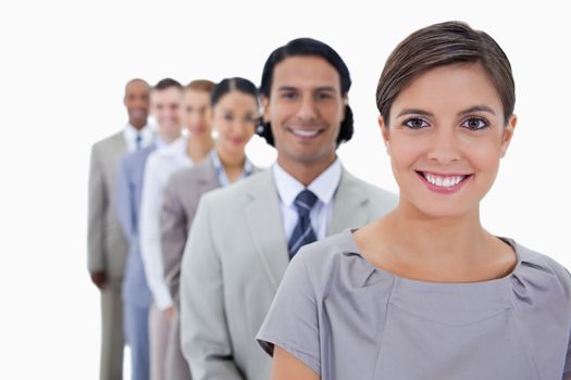 Big close-up of colleagues in a single line smiling and looking straight with focus on the first woman against white background
