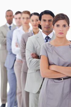 Close-up of serious workmates crossing their arms in a single line with focus on the first woman