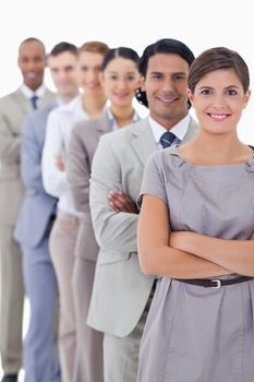 Close-up of workmates smiling in a single line crossing their arms with focus on the first woman