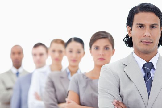 Big close-up of a serious business team crossing their arms in a single line looking straight with focus on the first man