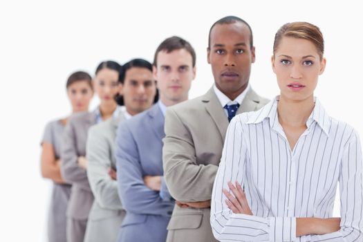 Close-up of serious people dressed in suits crossing their arms in a single line with focus on the first woman