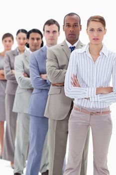 Serious colleagues dressed in suits crossing their arms in a single line with focus on the two first people 