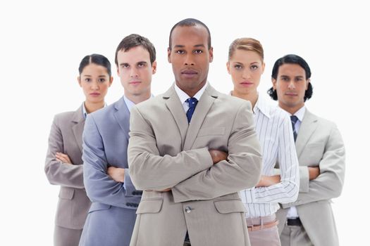 Close-up of a serious business team crossing their arms against white background