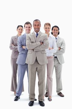 Smiling business team crossing their arms against white background