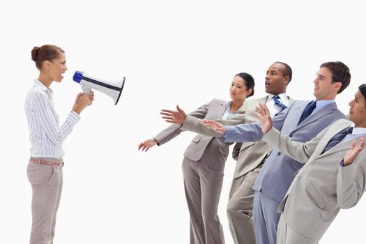 Woman yelling at people dressed in suits through a megaphone against white background