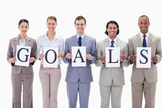 Happy business team holding the letters of GOALS against white background