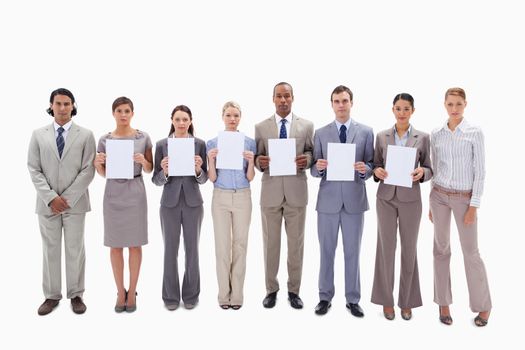 Business people holding six white supports for letters against white background