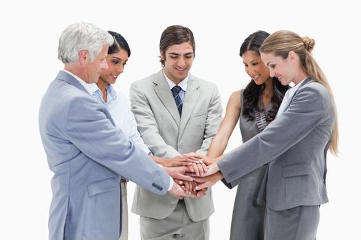 Smiling people putting their hands on each others against white background