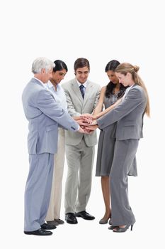 Business people putting their hands on each others against white background