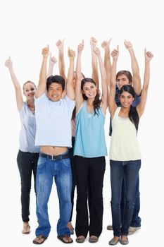 People smiling together raising their arms with their thumbs-up against white background