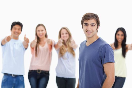 Man smiling with people approving behind him against white background