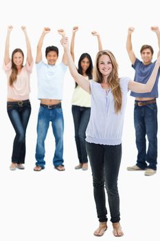 People in jeans with their arms raised against white background