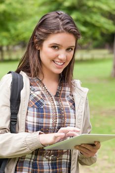 Portrait of a first-year student using a touch pad in a park