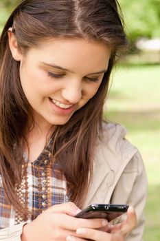 Close-up of a cute teenager using a smartphone in a park