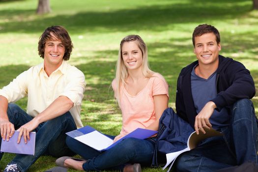 Portrait of three students in a park studying