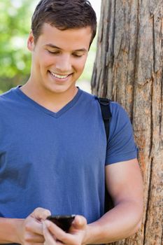 Close-up of a muscled young man using a smartphone in a park