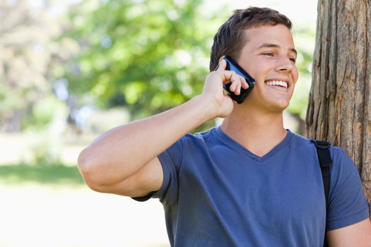 Close-up of a muscled student on the phone in a park