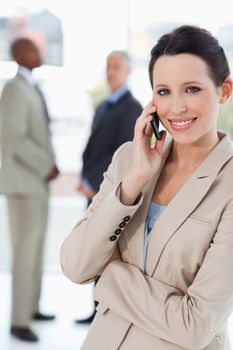 Young businesswoman talking on the mobile phone with her arms crossed