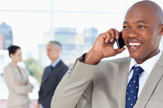 Young manager looking towards the side while laughing and talking on the phone