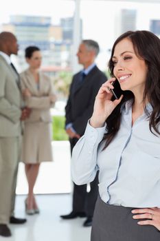 Young businesswoman talking on the phone and smiling with one hand on her hip