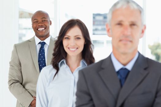 Young employee standing upright and following his smiling team