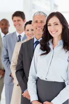 Young smiling businesswoman looking confident while being followed by her colleagues