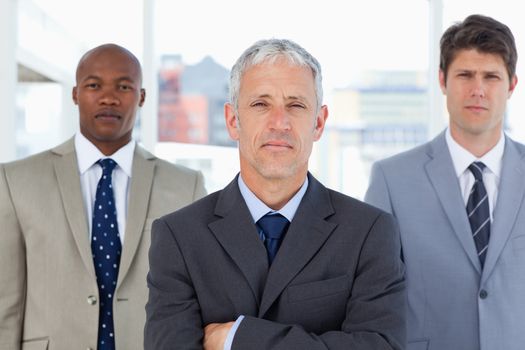 Serious manager standing in front of his two young executives