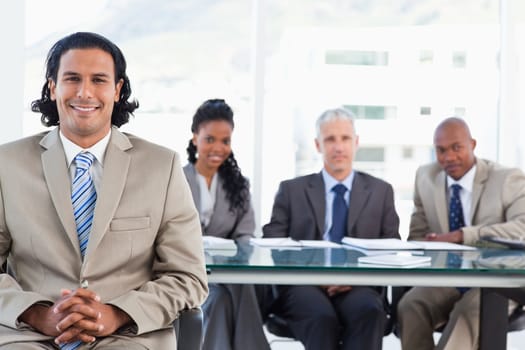 Executive smiling while sitting with her hands crossed on her leg