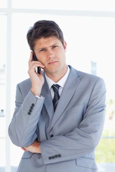 Young executive making a call while looking at the camera