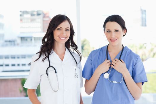 Smiling medical interns standing upright in their short sleeve uniforms