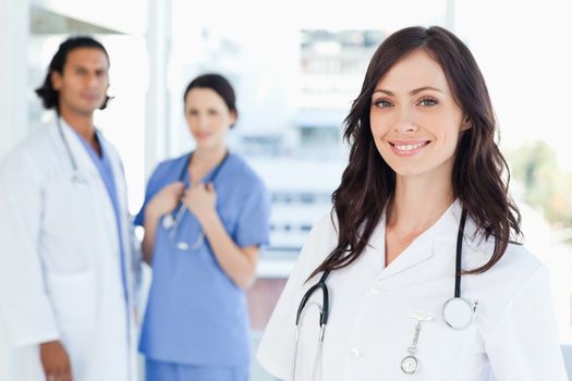 Smiling nurse standing in front of two co-workers