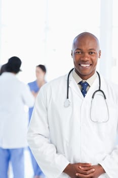 Smiling intern wearing a tie under his white lab coat