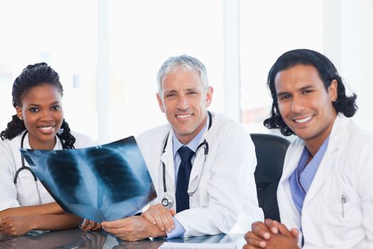 Confident medical team smiling while working hard with a patient's x-ray