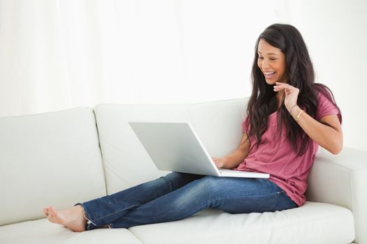 Latino student on a video chat while sitting on a sofa