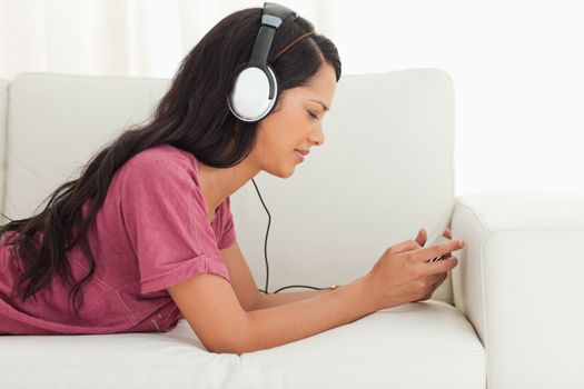 Young Latino frowning while listening to music on a sofa