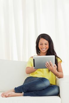 Happy Latino using a touch pad on a sofa