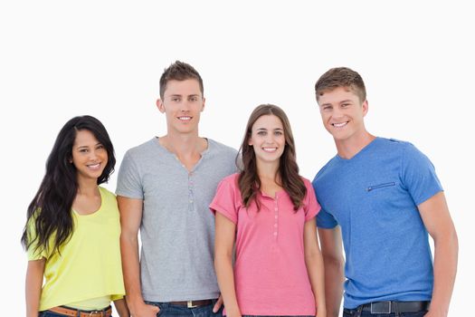 Four people standing beside each other and smiling while they all look at the camera