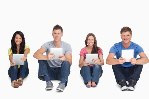 A group of people holding their tablet pc's in their hands as they all look at the camera