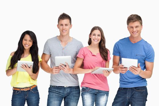 A smiling group looking at the camera and holding tablets in their hands