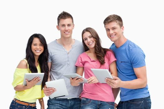 A group smiling as they look at the camera with tablet pc's in their hands