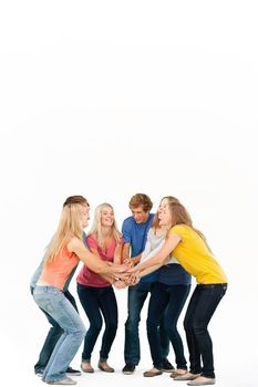 Group of friends about to cheer with their hands stacked smiling as they look at one another