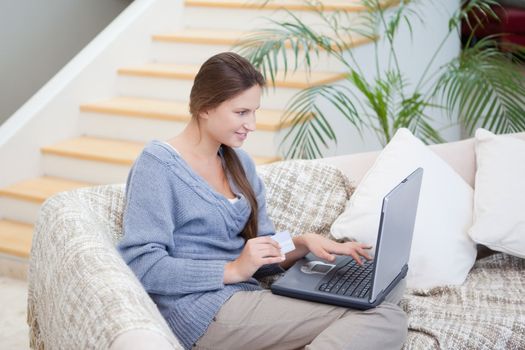 Women sitting on a sofa while using a laptop in a sitting room