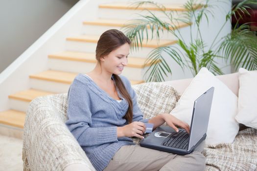 Woman sitting on a sofa while using a notebook in a sitting room