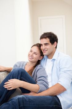 Couple sitting while embracing each other indoors