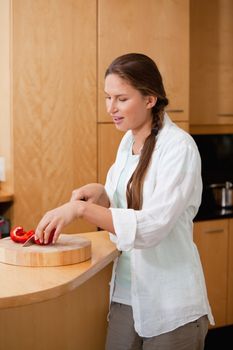 Woman cutting a pepper in a kitchen