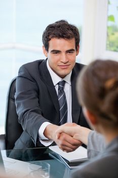 Businessman shaking hands with a Businesswoman  in an office