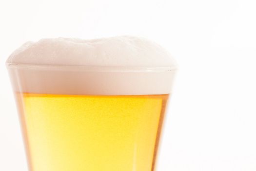 Top of glass full of beer and foam against a white background
