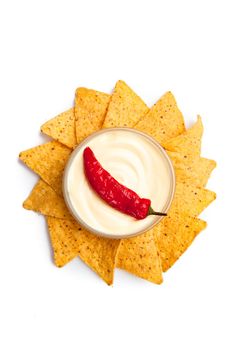 Pepper dipped into a bowl of white dip surrounded by nachos