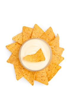 Bowl of white dip surrounded by nachos in circle