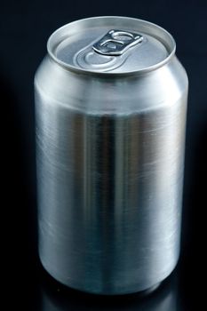 Close up of an aluminium closed can against a black background